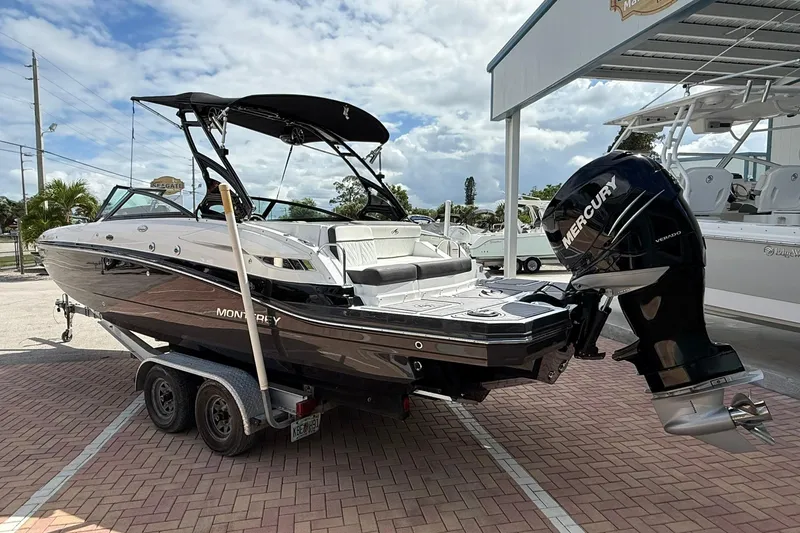 Slide: The Image of 2018 Monterey M-65 boat on trailer with Mercury outboard motor, parked outdoors. - 3