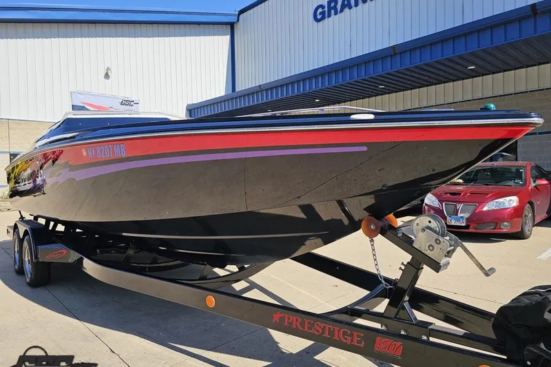 Slide: The Image of 2005 Baja 25 Outlaw boat on trailer, parked outside a building. - 11