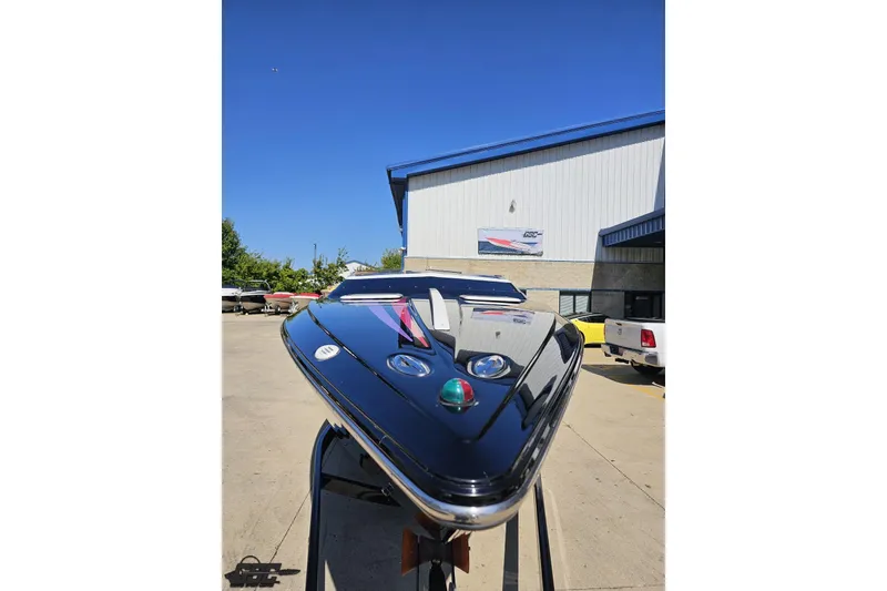 Slide: The Image of 2005 Baja 25 Outlaw boat displayed outdoors on a sunny day. - 13