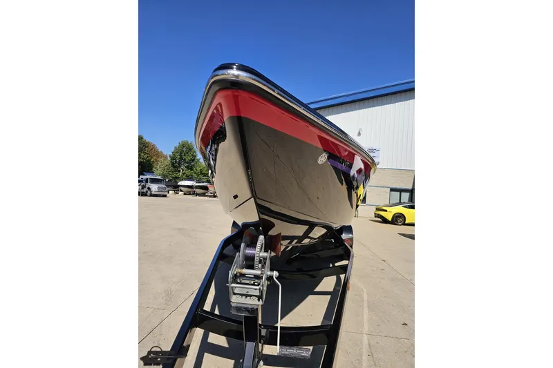 Slide: The Image of 2005 Baja 25 Outlaw boat on trailer, red and black hull, outdoor setting. - 16