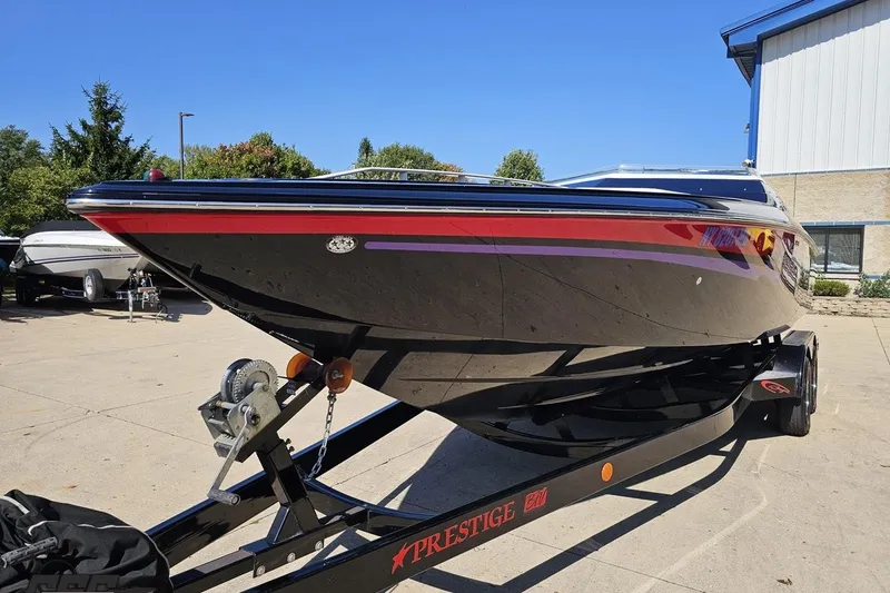 Slide: The Image of 2005 Baja 25 Outlaw boat on trailer, sleek design, vibrant colors, outdoor setting. - 17