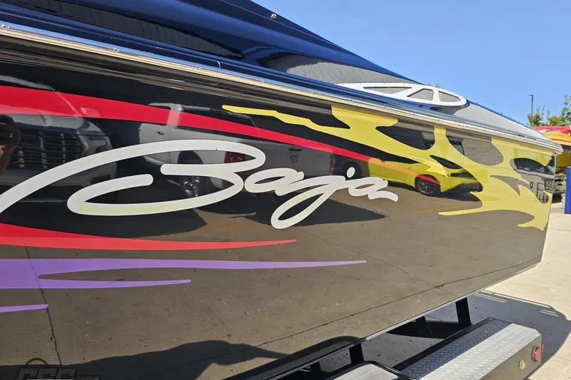 Slide: The Image of 2005 Baja 25 Outlaw boat with vibrant flame graphics and sleek design. - 23