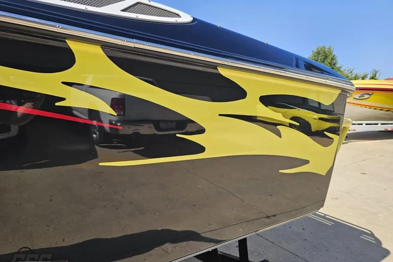 Slide: The Image of 2005 Baja 25 Outlaw boat with yellow flame graphics on a sunny day. - 24