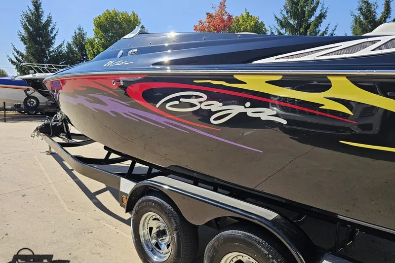 Slide: The Image of 2005 Baja 25 Outlaw boat with vibrant graphics on a trailer. - 29