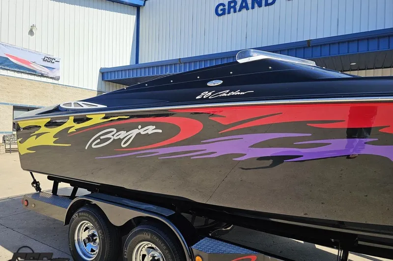 Slide: The Image of 2005 Baja 25 Outlaw boat with vibrant flame graphics on a trailer. - 3