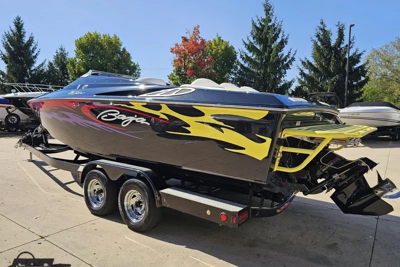 Slide: The Image of 2005 Baja 25 Outlaw speedboat with vibrant flame graphics on a trailer. - 31