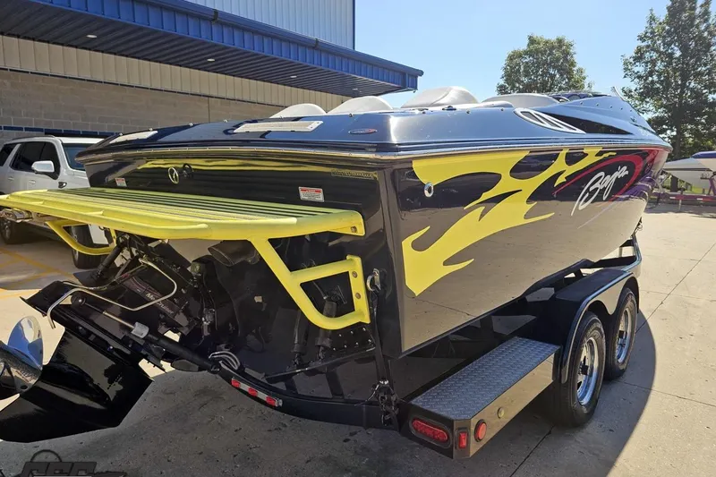 Slide: The Image of 2005 Baja 25 Outlaw speedboat with vibrant yellow flame design on trailer. - 37