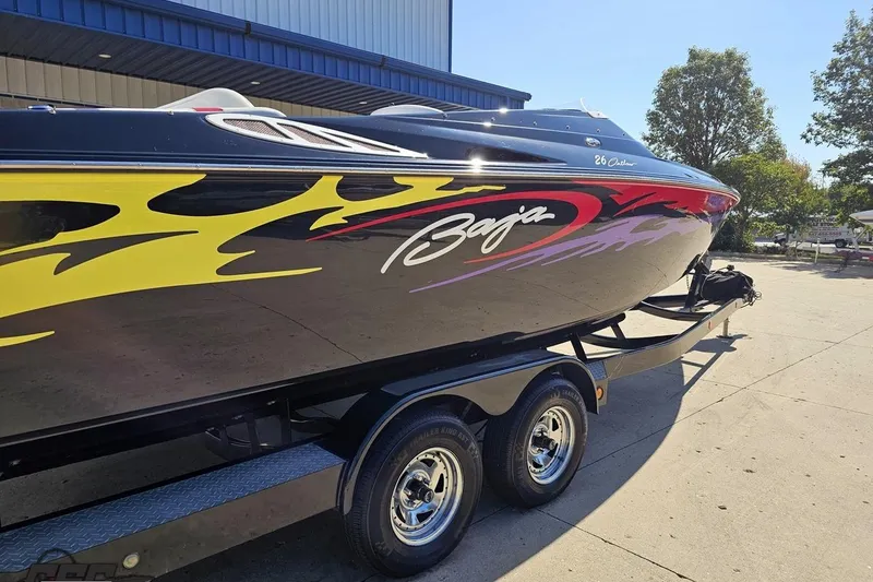 Slide: The Image of 2005 Baja 25 Outlaw speedboat with vibrant flame graphics on a trailer. - 39