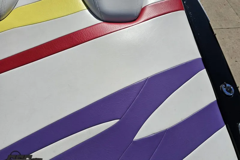 Slide: The Image of Colorful seat upholstery on a 2005 Baja 25 Outlaw boat, featuring red, yellow, and purple accents. - 48