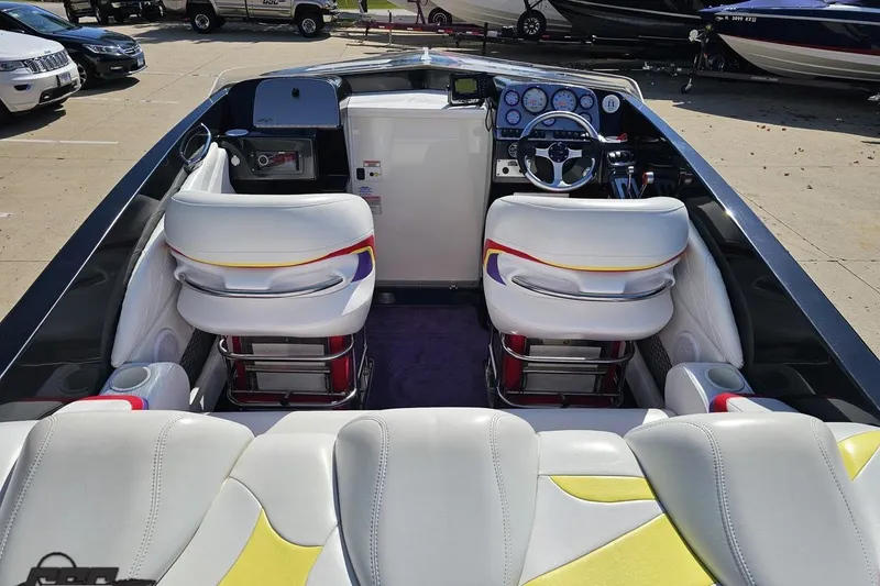 Slide: The Image of 2005 Baja 25 Outlaw boat interior with white seats and colorful accents. - 49