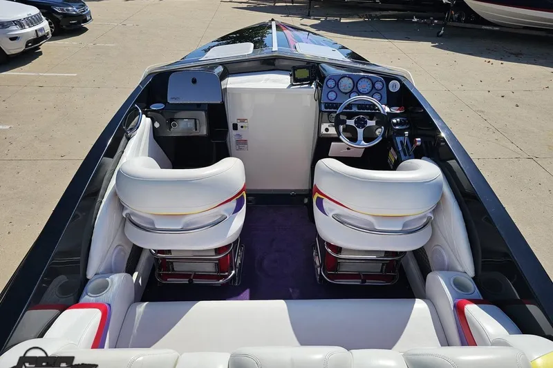 Slide: The Image of 2005 Baja 25 Outlaw boat interior with white seats and modern dashboard controls. - 50