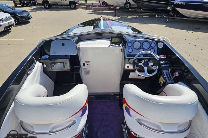 Slide: The Image of 2005 Baja 25 Outlaw boat interior with white seats and detailed dashboard. - 51