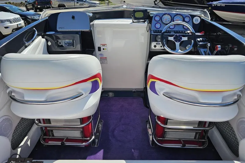 Slide: The Image of 2005 Baja 25 Outlaw boat cockpit with white seats and colorful accents. - 53