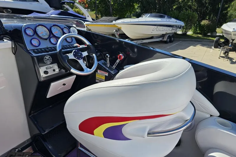 Slide: The Image of 2005 Baja 25 Outlaw boat cockpit with steering wheel and gauges. - 56