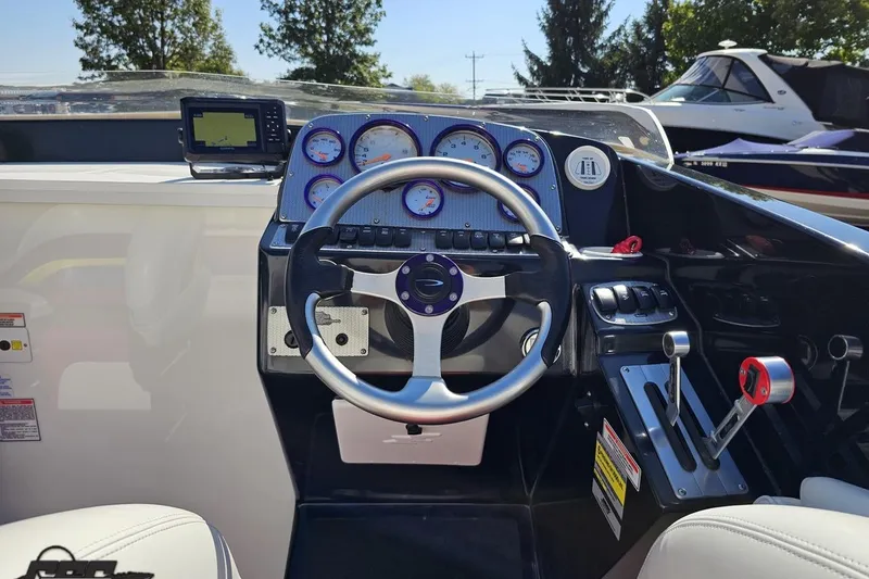 Slide: The Image of 2005 Baja 25 Outlaw boat dashboard with steering wheel and gauges in sunlight. - 58