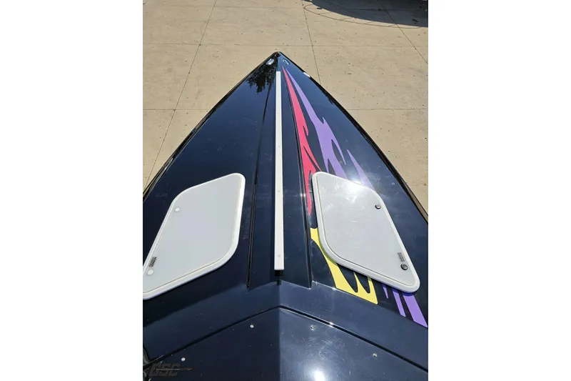 Slide: The Image of 2005 Baja 25 Outlaw boat bow with vibrant graphics and deck hatches. - 75
