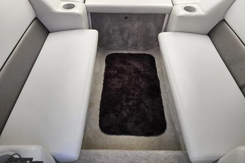 Slide: The Image of 2005 Baja 25 Outlaw interior with white seating and dark carpet. - 77