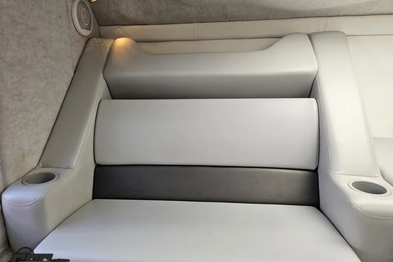 Slide: The Image of 2005 Baja 25 Outlaw boat interior with gray cushioned seating and cup holders. - 79
