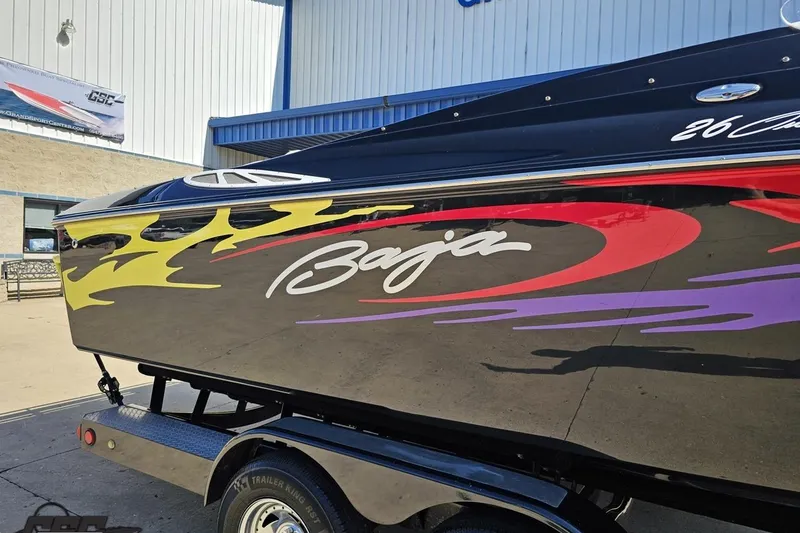 Slide: The Image of 2005 Baja 25 Outlaw boat with vibrant graphics on a trailer. - 8