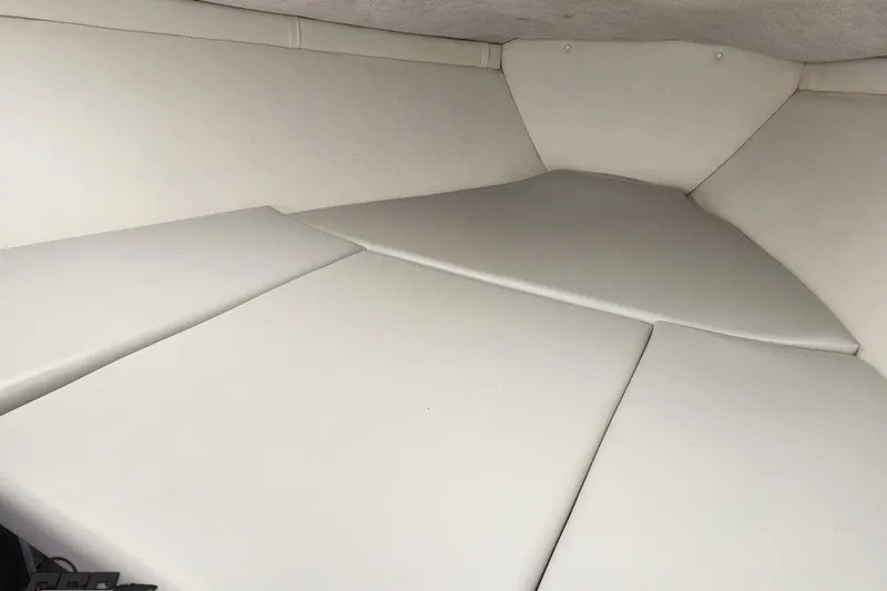 Slide: The Image of 2005 Baja 25 Outlaw boat interior with white cushioned seating. - 80