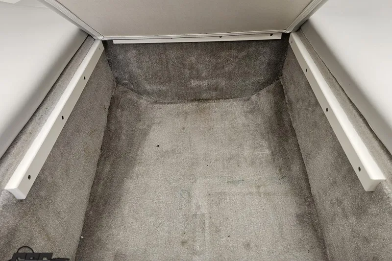 Slide: The Image of Interior storage compartment of a 2005 Baja 25 Outlaw boat, featuring gray carpeting. - 81
