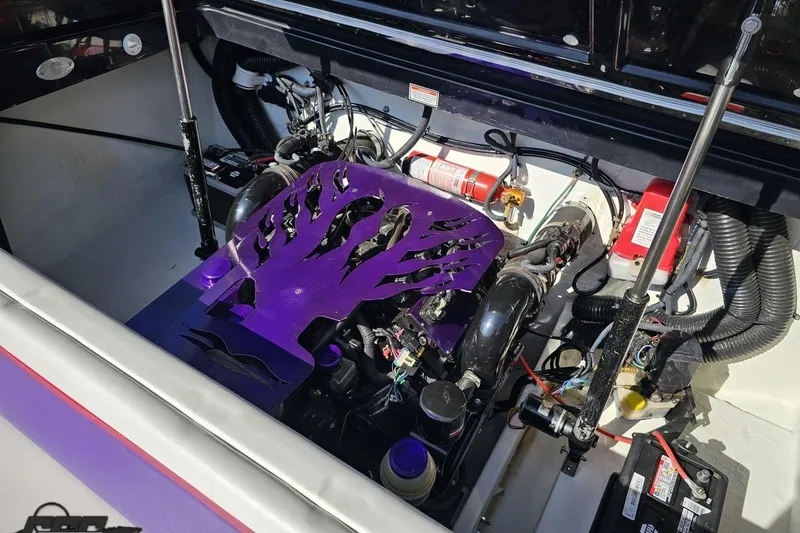 Slide: The Image of Engine compartment of a 2005 Baja 25 Outlaw boat with custom purple cover. - 96