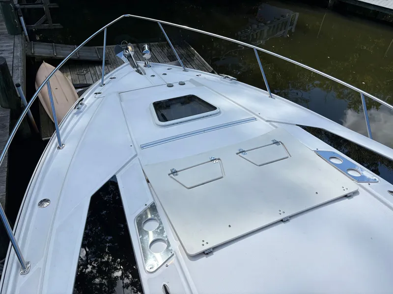 Slide: The Image of 2016 Regal 35 Sport Coupe boat deck with railing, docked by calm water. - 2