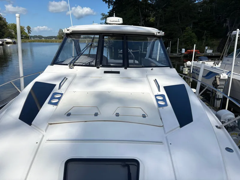 Slide: The Image of 2016 Regal 35 Sport Coupe yacht docked by a serene lake. - 4