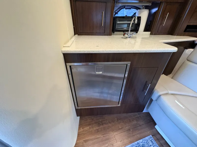 Slide: The Image of Interior of 2016 Regal 35 Sport Coupe with modern kitchenette and stainless steel appliances. - 40