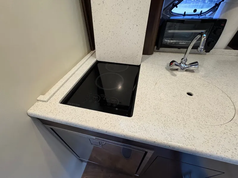 Slide: The Image of Modern kitchen area in 2016 Regal 35 Sport Coupe with stovetop and sink. - 44