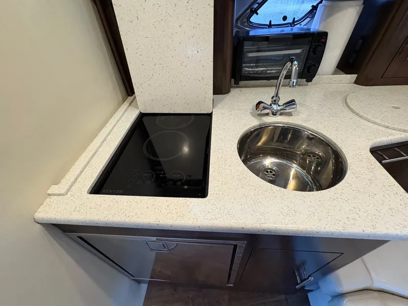 Slide: The Image of 2016 Regal 35 Sport Coupe kitchen with induction cooktop and stainless steel sink. - 45