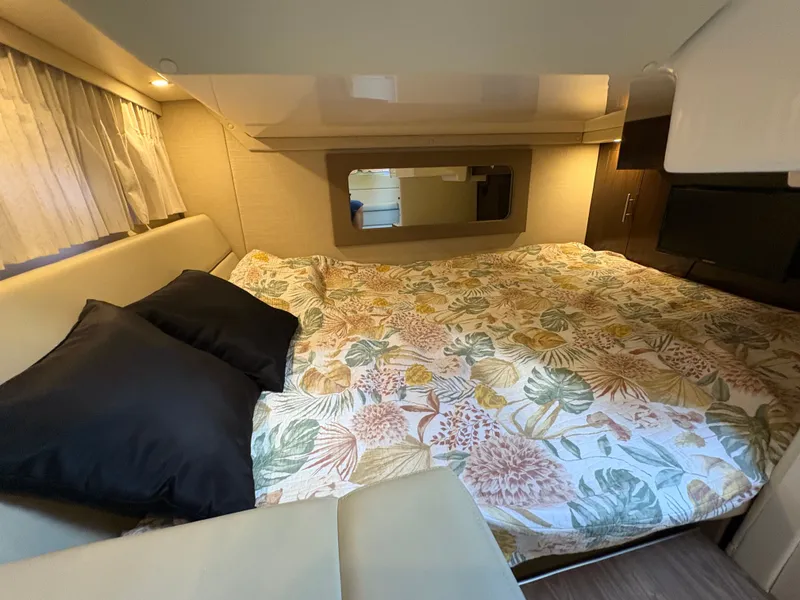 Slide: The Image of Cozy cabin interior of 2016 Regal 35 Sport Coupe with floral bedding and soft lighting. - 47