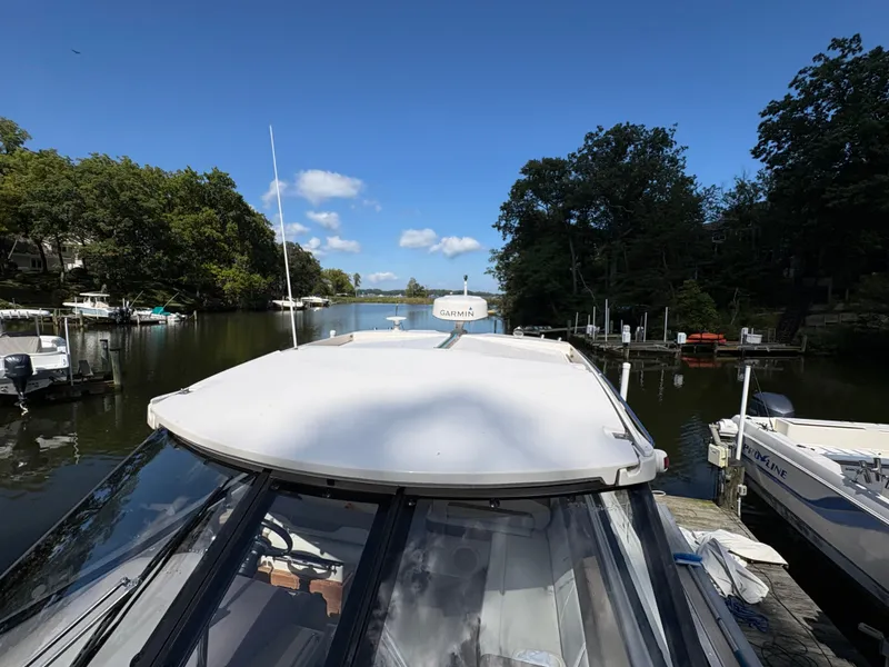 Slide: The Image of 2016 Regal 35 Sport Coupe docked on a serene river with lush greenery. - 6