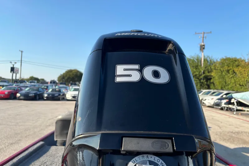 Slide: The Image of 2024 Bass Tracker XL boat with Mercury engine, outdoor setting, clear blue sky. - 13