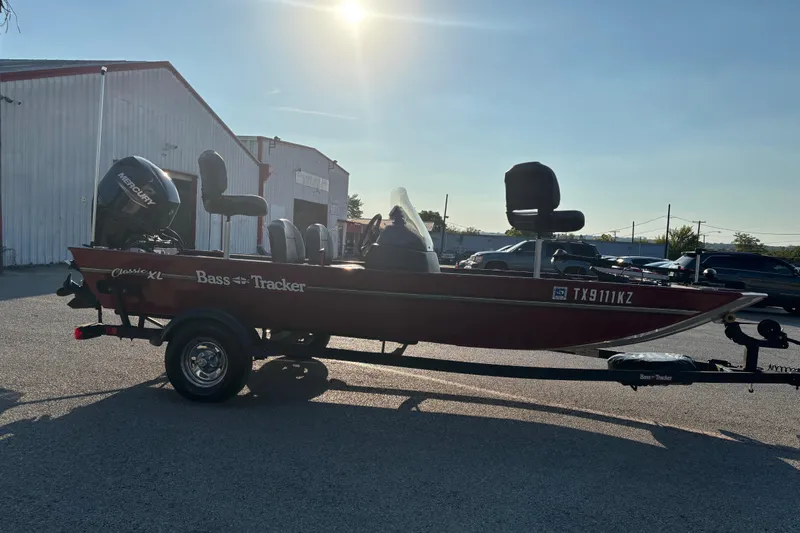 Slide: The Image of 2024 Bass Tracker XL boat trailer with red hull and black cover. - 17