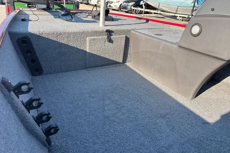 Slide: The Image of 2024 Bass Tracker XL storage compartment with metal interior and carpeted edges. - 30