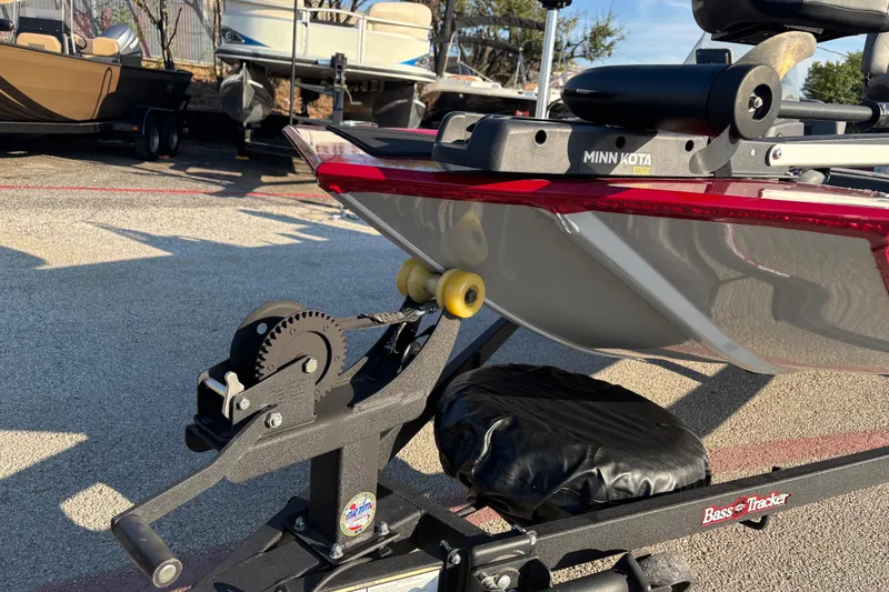 Slide: The Image of 2024 Bass Tracker XL boat with Minn Kota trolling motor, parked outdoors. - 6