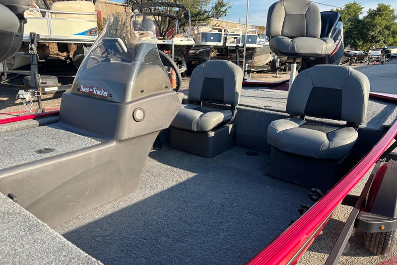 Slide: The Image of 2024 Bass Tracker XL boat in vibrant red, parked on a trailer outdoors. - 9