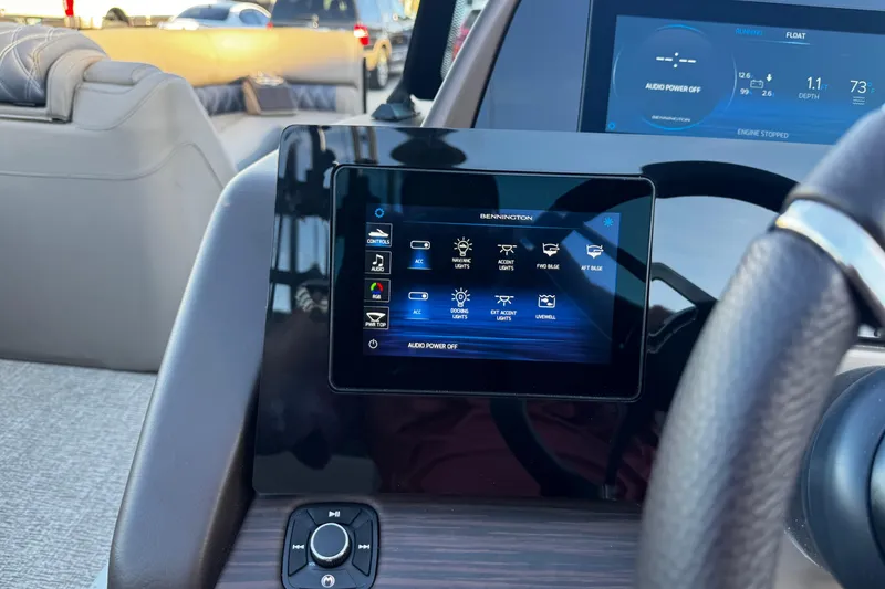Slide: The Image of 2025 Bennington 23RSB dashboard with touchscreen controls and steering wheel. - 11