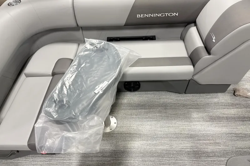 Slide: The Image of 2025 Bennington 20 S Fishing boat interior with gray seating and plastic-covered table. - 2