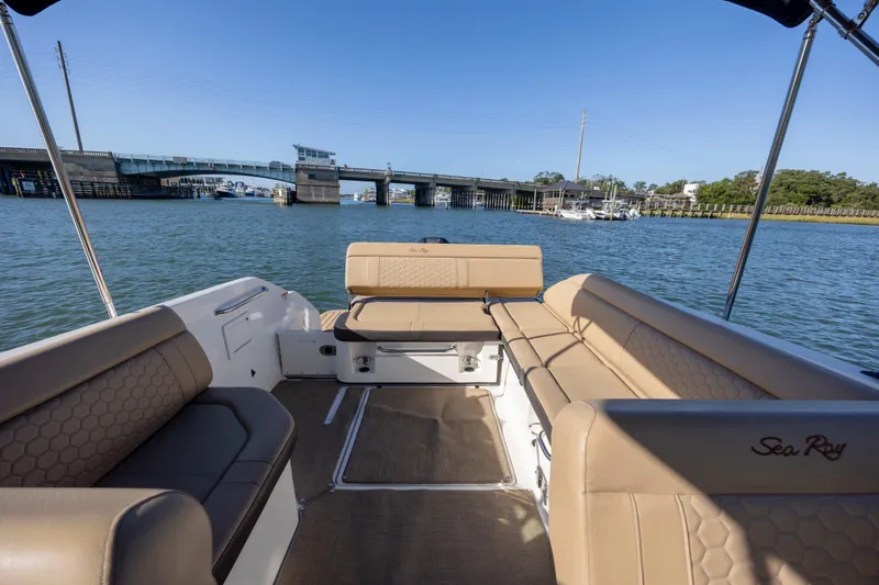 Slide: The Image of 2019 Sea Ray SDX 250 Outboard boat interior with tan seating, near a bridge on calm water. - 43