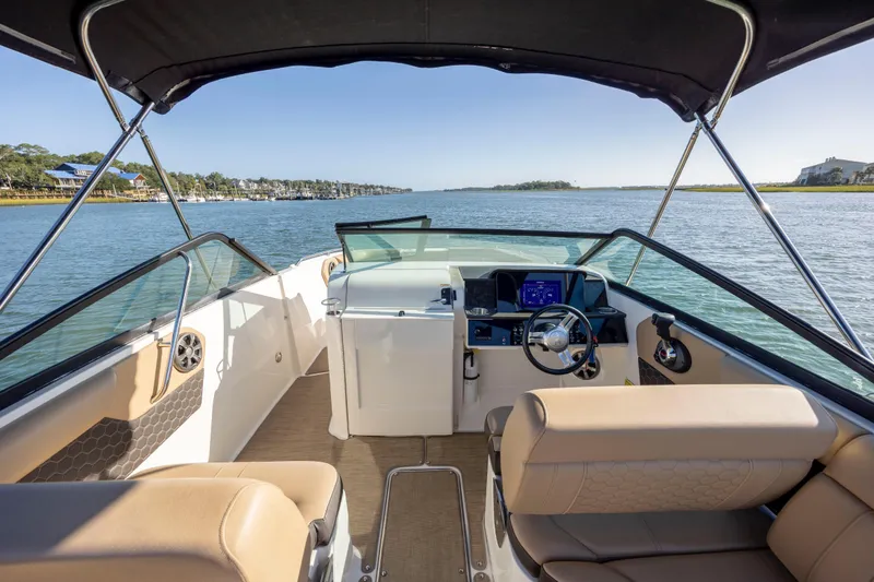 Slide: The Image of 2019 Sea Ray SDX 250 Outboard boat interior with steering wheel, seats, and water view. - 45