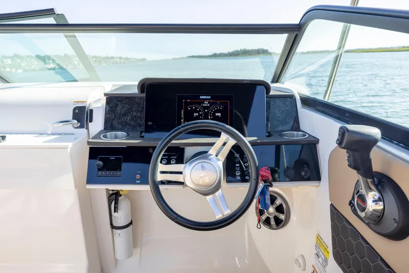 Slide: The Image of 2019 Sea Ray SDX 250 Outboard helm with steering wheel and control panel. - 48