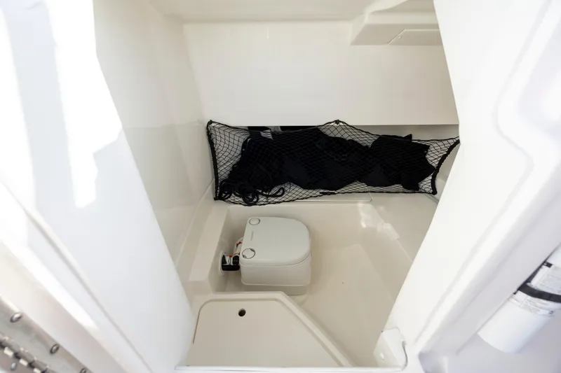 Slide: The Image of 2019 Sea Ray SDX 250 Outboard interior with storage net and compact toilet. - 49