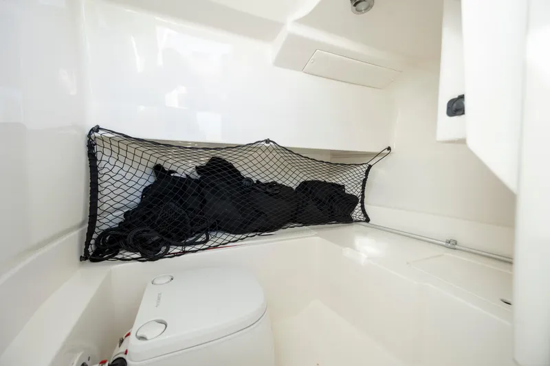 Slide: The Image of 2019 Sea Ray SDX 250 Outboard interior with storage net and compact toilet. - 50