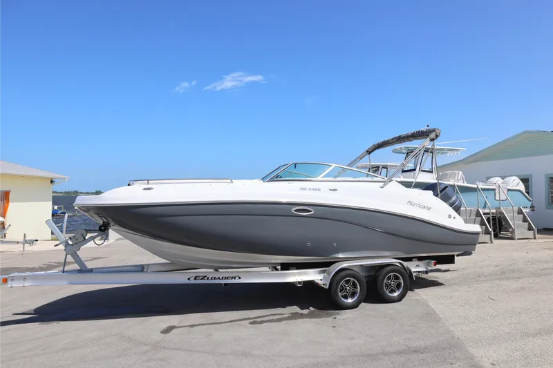 Slide: The Image of 2026 Hurricane SunDeck 2486 OB boat with Yamaha engine on trailer, sunny day. - 23