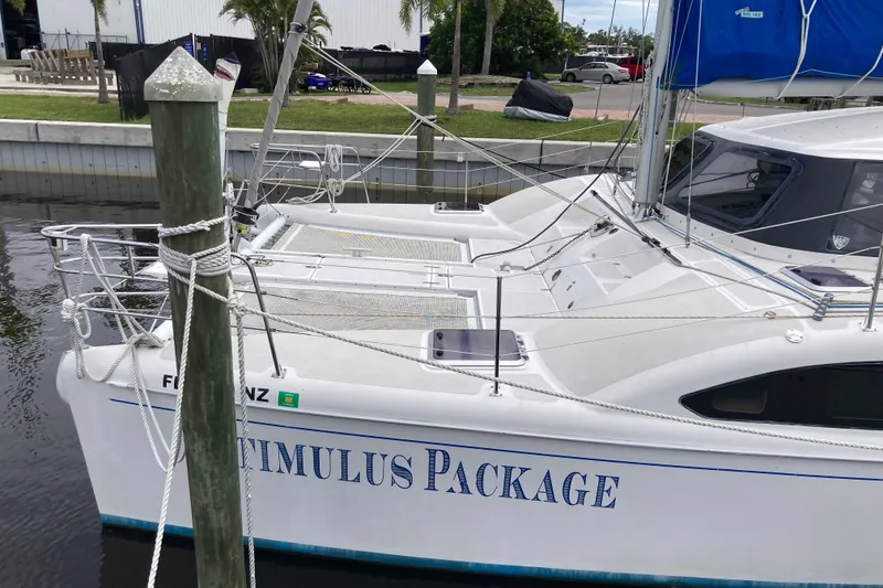 Slide: The Image of 2009 Seawind 36 1000XL catamaran docked, named "Stimulus Package." - 2