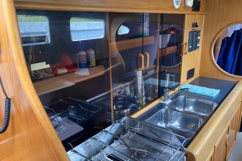 Slide: The Image of 2009 Seawind 36 1000XL yacht kitchen with dual sinks and wooden cabinetry. - 20