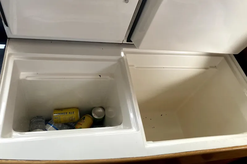 Slide: The Image of Open storage compartments on a 2009 Seawind 36 1000XL, containing drinks and empty space. - 24
