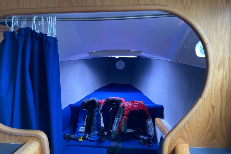 Slide: The Image of Interior cabin of 2009 Seawind 36 1000XL with blue seating and life jackets. - 26